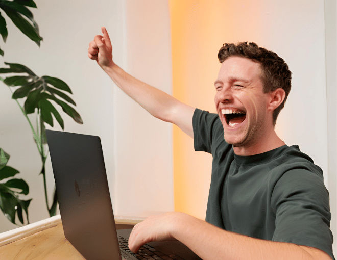 Top Strategies for Winning on Trusted Lottery Sites A white mans jubilant smile illuminates his face as he gazes at his laptop hands raised in victory bathed in the glow of a screen - Top Strategies for Winning on Trusted Lottery Sites